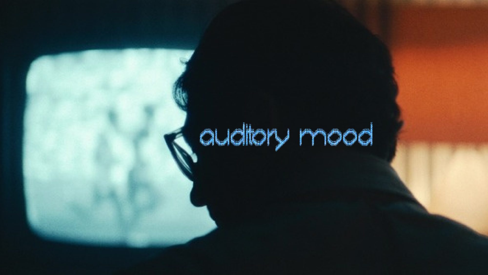 Auditory mood: a man in silhouette watching a glowing screen