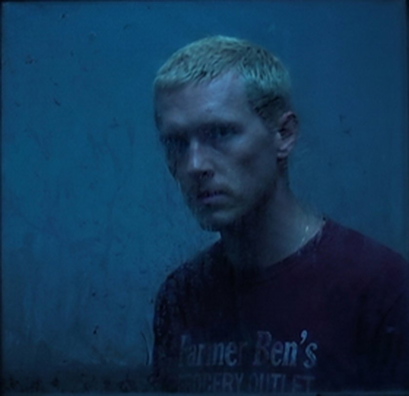 Martin, washed in blue light, in his Farmer Ben's work shirt